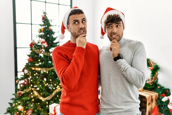 Young Gay Couple Standing Christmas Tree Wearing Hat Thinking Worried — ストック写真