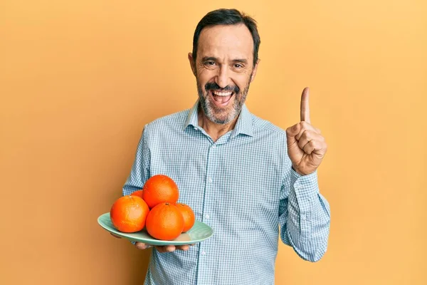 Homem Hispânico Meia Idade Segurando Prato Com Laranjas Frescas Sorrindo — Fotografia de Stock