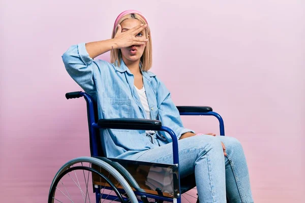 Красивая Блондинка Сидящая Инвалидной Коляске Подглядывая Лицо Глаза Рукой Глядя — стоковое фото