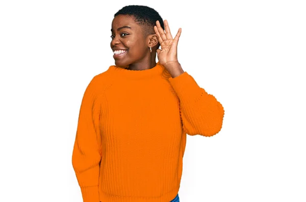 噂やゴシップに耳を傾ける耳の上に手で笑みを浮かべてカジュアルな服を着て若いアフリカ系アメリカ人の女性 聴覚障害の概念 — ストック写真