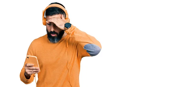 Hispanic Man Beard Using Smartphone Wearing Headphones Stressed Frustrated Hand — Stockfoto