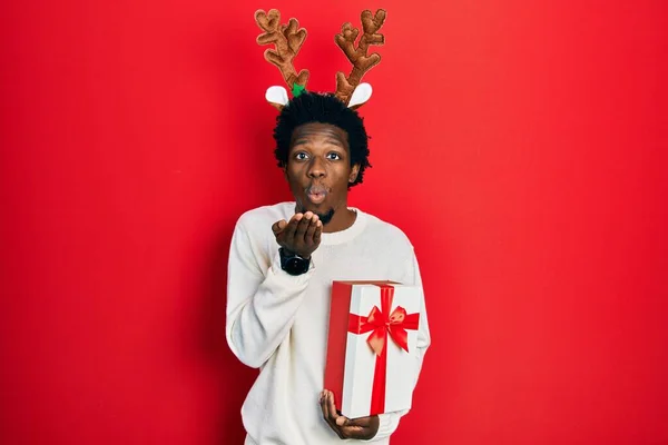 Young African American Man Wearing Deer Christmas Hat Holding Gift — Stockfoto