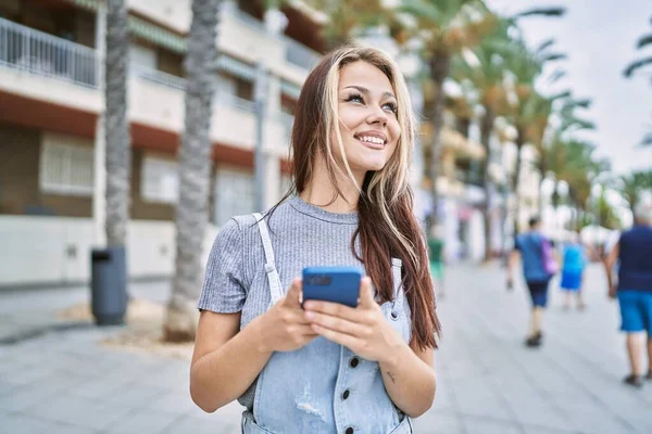 Νεαρή Καυκάσια Κοπέλα Χαμογελώντας Ευτυχισμένη Χρησιμοποιώντας Smartphone Στην Πόλη — Φωτογραφία Αρχείου