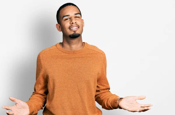 両手を開いて手のひらを示す笑みを浮かべてカジュアルな服を着て若いアフリカ系アメリカ人男性 提示し 広告の比較とバランス — ストック写真