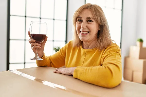 中世ブロンド女性笑顔幸せな飲む赤ワインで新しい家 — ストック写真