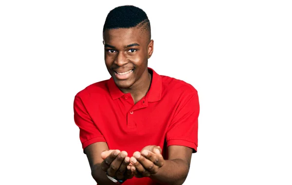 Молодий Афроамериканець Червоній Сорочці Посміхається Долонями Які Отримують Або Жестикулюють — стокове фото