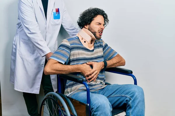 Przystojny Hiszpan Siedzący Wózku Inwalidzkim Noszący Kołnierzyk Ręką Brzuchu Mdłości — Zdjęcie stockowe