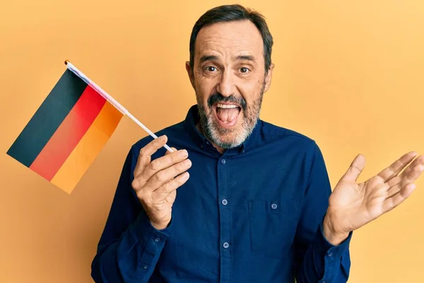 Středověký Hispánský Muž Držící Německou Vlajku Oslavující Úspěch Šťastným Úsměvem — Stock fotografie