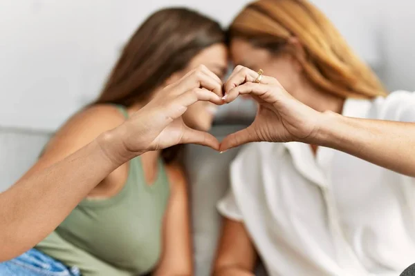 Mother Daughter Smiling Confident Make Heart Gesture Hands Home — Φωτογραφία Αρχείου