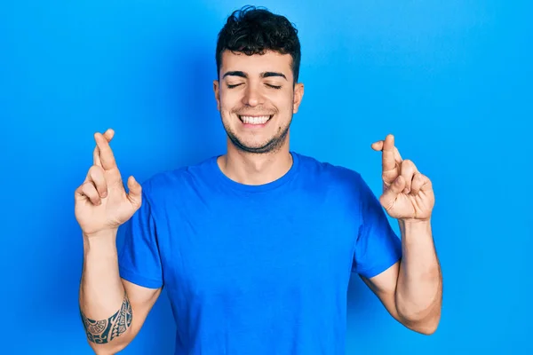 Young Hispanic Man Wearing Casual Blue Shirt Gesturing Finger Crossed — Foto Stock