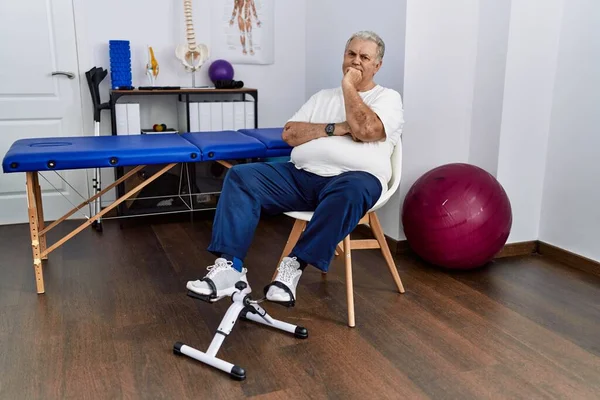 Homem Caucasiano Sênior Clínica Fisioterapia Usando Pedal Exercitador Olhando Confiante — Fotografia de Stock