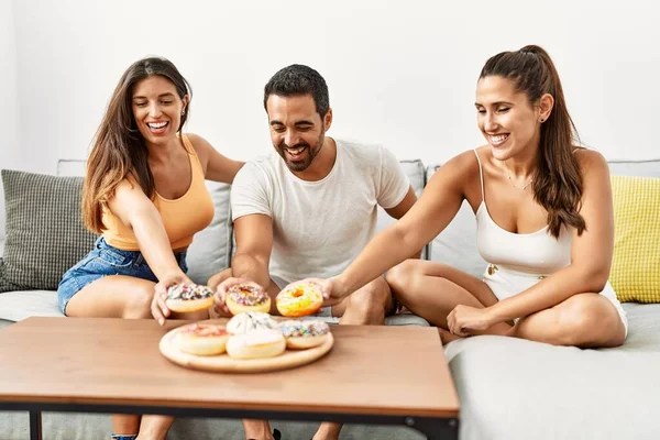 Τρεις Ισπανοί Φίλοι Χαμογελούν Χαρούμενοι Τρώγοντας Ντόνατ Στο Σπίτι — Φωτογραφία Αρχείου