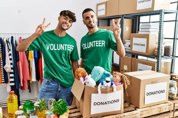 Young Gay Couple Wearing Volunteer Shirt Donations Stand Smiling Looking —  Fotos de Stock