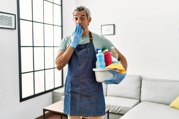 Middle Age Hispanic Man Wearing Cleaner Apron Holding Cleaning Products — стоковое фото