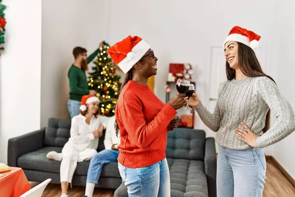 Grupo Jovens Comemorando Natal Duas Mulheres Sorrindo Feliz Beber Vinho — Fotografia de Stock