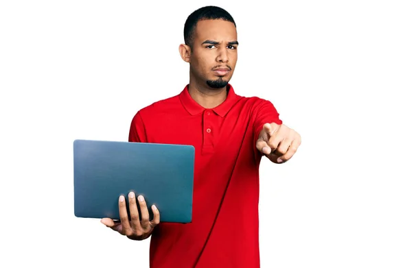 Молодой Африканский Американец Работающий Ноутбуком Указывая Пальцем Камеру Уверенный Себе — стоковое фото