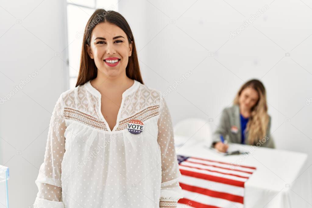Young american voter woman wearing i voted badge standing at electoral college.