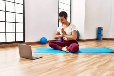 Genç İspanyol kadın spor merkezinde yoga dersi aldığı için kendinden emin gülümsüyor.