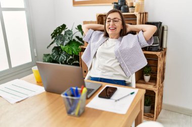 Orta yaşlı İspanyol kadın işkadını iş yerinde dinleniyor.