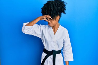 Afro saçlı, karate kimonosu ve siyah kuşak giyen Afro-Amerikalı bir kadın pis ve iğrenç bir koku alıyor. Nefesini burnu havada tutuyor. Kötü kokuyor. 
