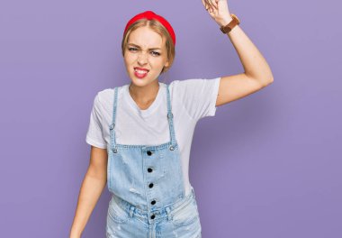 Kafkasyalı genç bir kız, gündelik giysiler giymiş kızgın ve kızgın. Öfkeyle bağırırken yumruğunu kaldırıyor. öfke ve agresif konsept. 