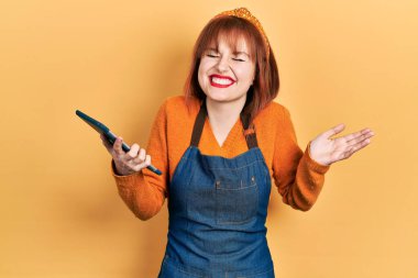 Kızıl saçlı genç kadın garsonluk önlüğü takıyor. Elinde dokunmatik bir cihaz var. Sipariş alıyor. Gururla bağırıyor, zaferi kutluyor ve başarıyı kutluyor. 