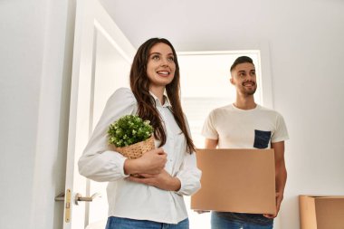 Genç İspanyol çift mutlu bir şekilde gülümsüyor. Karton kutular yeni evlerinde taşınıyor..