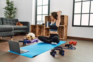 Evde esneme kursu aldığından emin bir şekilde gülümseyen genç İspanyol kadın.