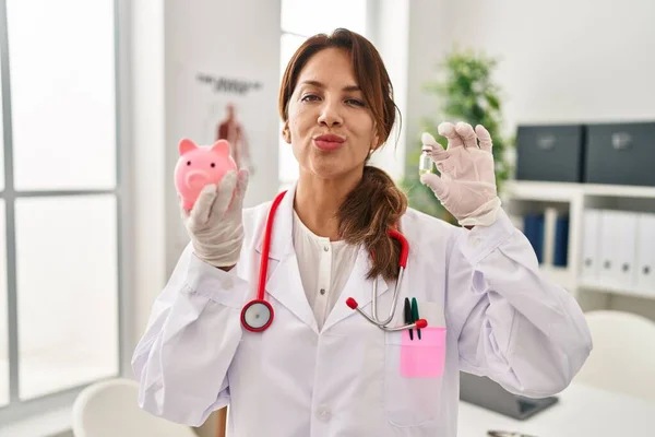 Hispanic Läkare Kvinna Håller Spargris Bank Tittar Kameran Blåser Kyss — Stockfoto