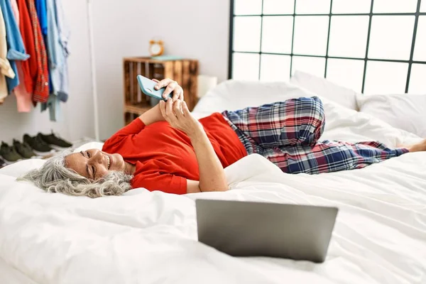 Жінка Середнього Віку Сірим Волоссям Допомогою Смартфона Лежить Ліжку Спальні — стокове фото