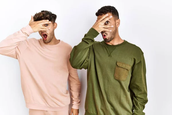 Young Gay Couple Standing Isolated White Background Peeking Shock Covering — Fotografia de Stock