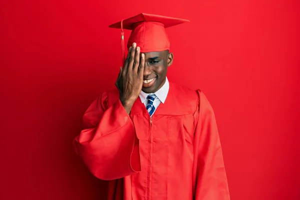 Mladý Africký Američan Čepici Slavnostním Županu Zakrývajícím Jedno Oko Rukou — Stock fotografie