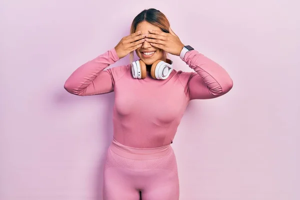 Beautiful Hispanic Woman Wearing Gym Clothes Using Headphones Covering Eyes — Foto Stock
