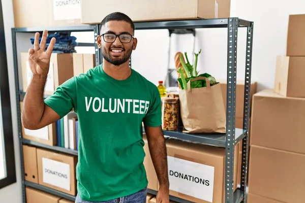 Joven Indio Voluntario Sosteniendo Donaciones Cuadro Mostrando Señalando Hacia Arriba —  Fotos de Stock