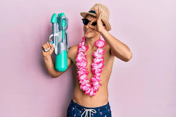 Young Caucasian Man Wearing Swimsuit Hawaiian Lei Holding Watergun Smiling — Foto de Stock