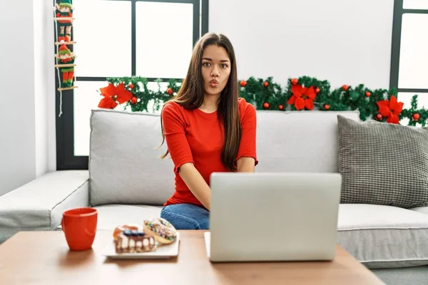 Jovem Morena Usando Laptop Sentado Sofá Natal Fazendo Cara Peixe — Fotografia de Stock