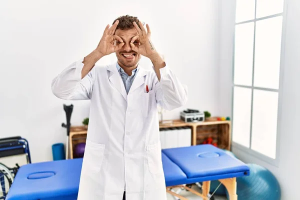 Handsome Young Man Working Pain Recovery Clinic Doing Gesture Binoculars — Stockfoto