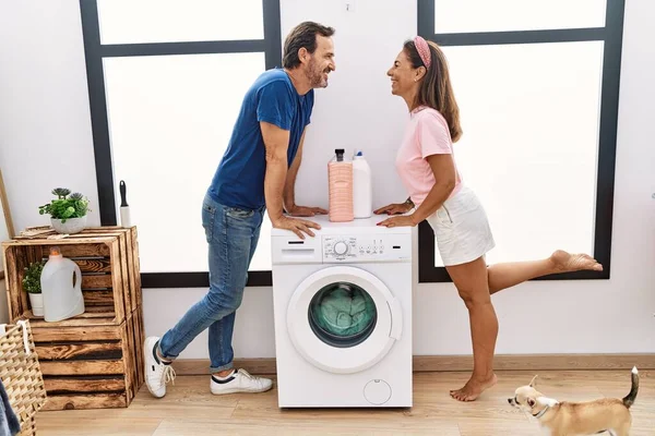 中年男性と女性カップル笑顔自信に満ちた洗濯服でランドリールーム — ストック写真