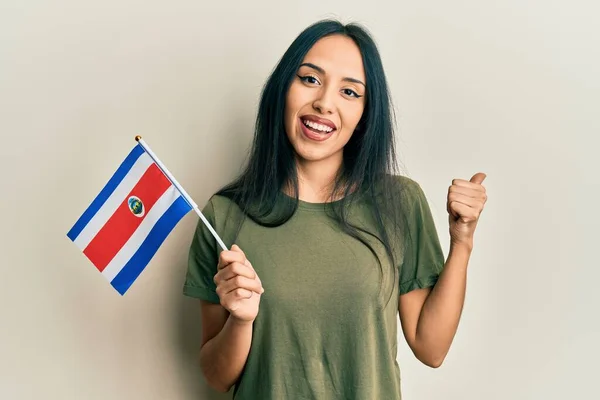 若いですヒスパニック女の子保持Cosa Rica Flag指して親指へザ側笑顔幸せとともにオープン口 — ストック写真