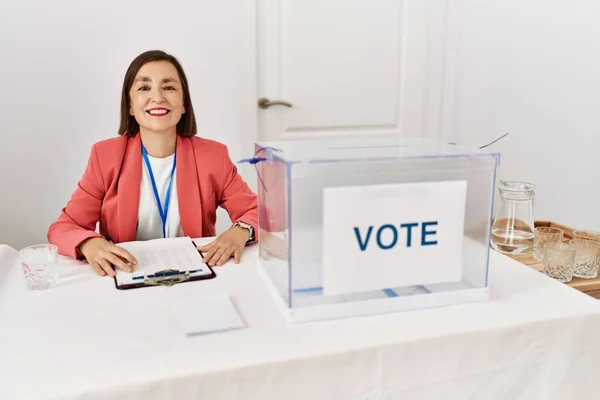 美しい中年のヒスパニック系の女性の政治選挙での投票に直面して幸せとクールな笑顔で座っている 運のいい人 — ストック写真