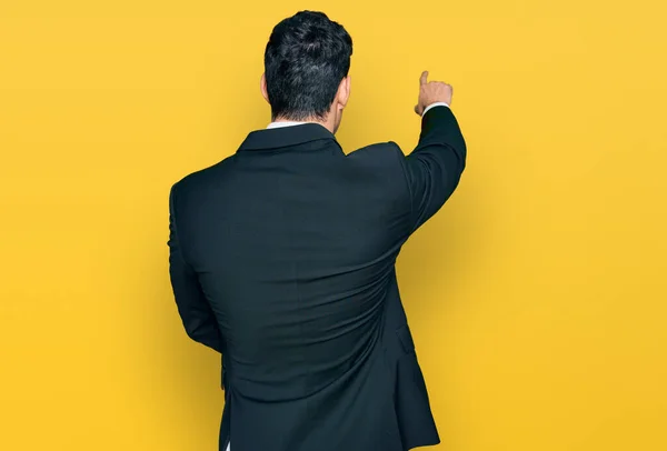 Handsome Hispanic Man Wearing Business Clothes Posing Backwards Pointing Ahead — 图库照片