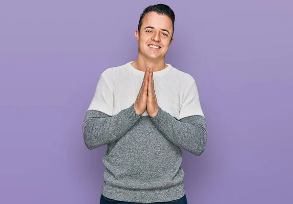 Handsome Young Man Wearing Casual Winter Sweater Praying Hands Together — Stock fotografie