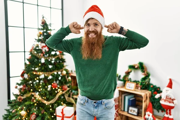 Redhead Man Med Långt Skägg Bär Jul Hatt Genom Julgran — Stockfoto