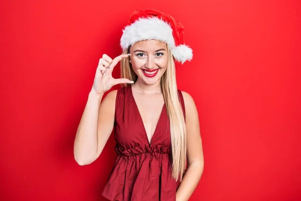 Молодая Блондинка Рождественской Шляпе Улыбается Уверенно Жестикулирует Рукой Делая Знак — стоковое фото