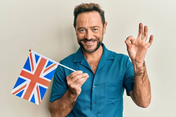 Orta Yaşlı Adam Birleşik Krallık Bayrağını Tutuyor Parmaklarıyla Imza Atıyor — Stok fotoğraf