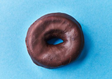  Mavi arka planda tek lezzetli çikolatalı donut.