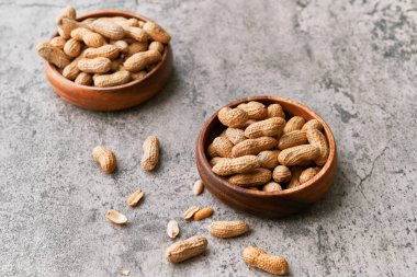 Beton bir yüzeyde kasede bir avuç fıstık.