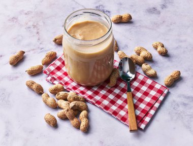  Fıstık ezmesi ve fıstık ezmesi kremalı mermer bir yüzey.