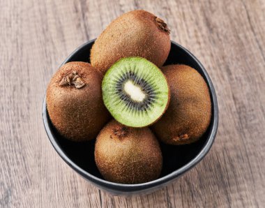  Bir kase kivi ve tahta bir masa dilimi.