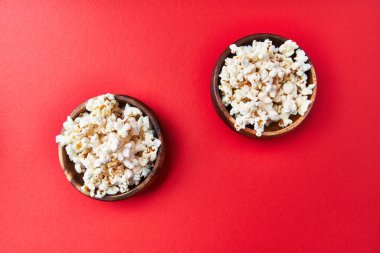  Kırmızı arka planda tuzlu patlamış mısır kaseleri